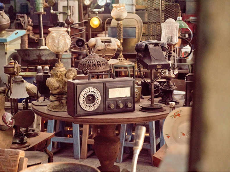 old radio on a table with other antiques in the background